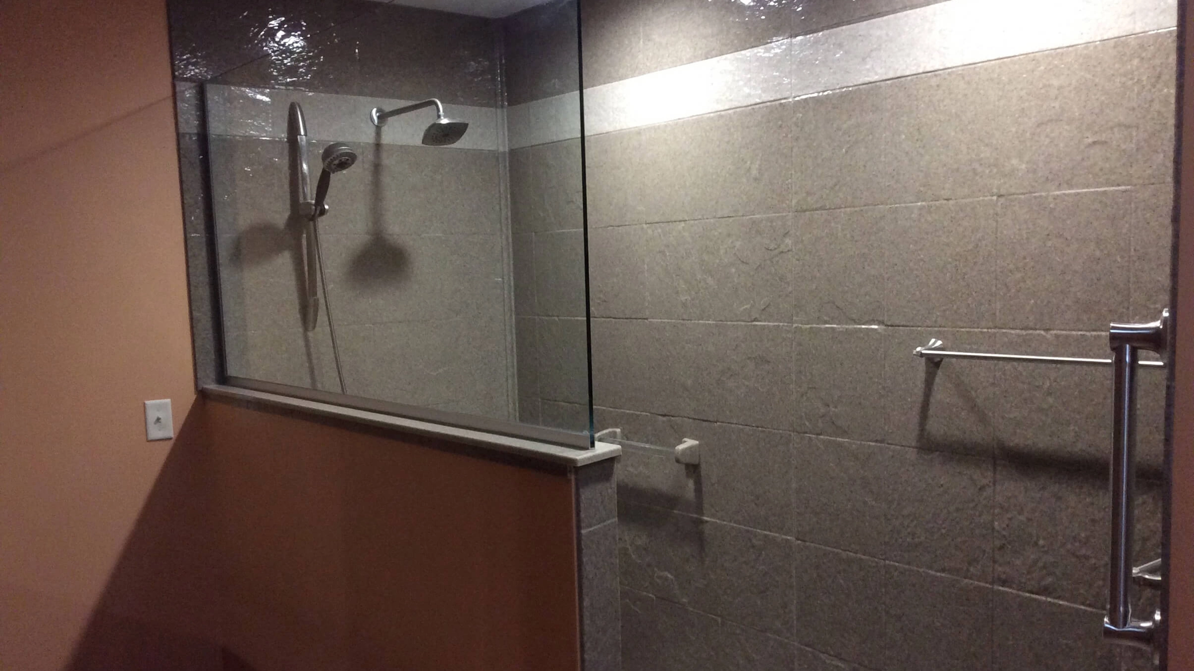 A minimalist bathroom shower corner with textured white Onyx wall panels.