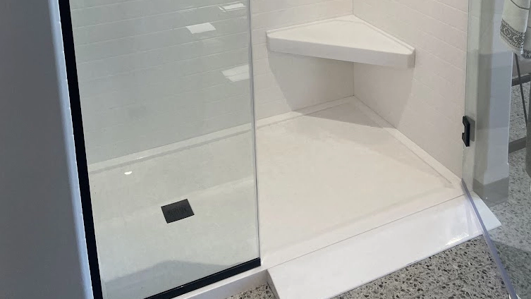 Modern walk-in shower featuring a white Onyx shower pan with a sleek square drain. 